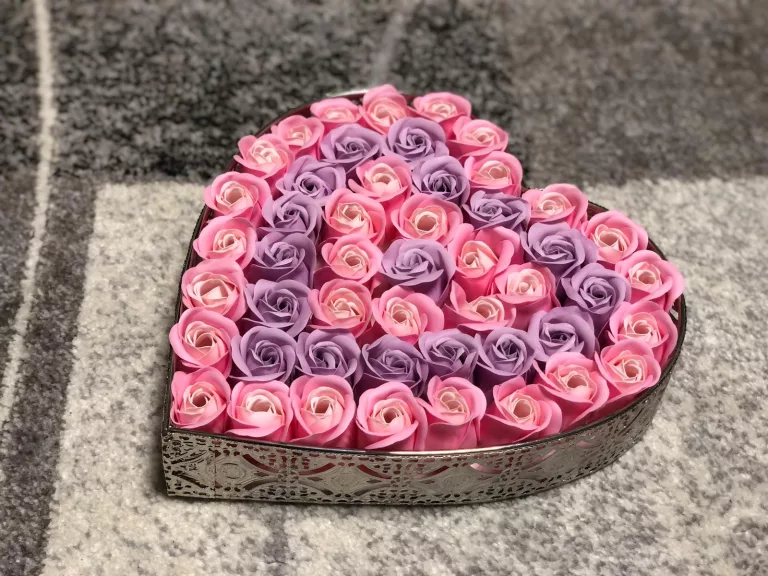 Herz mit rosanen und violetten Rosen.