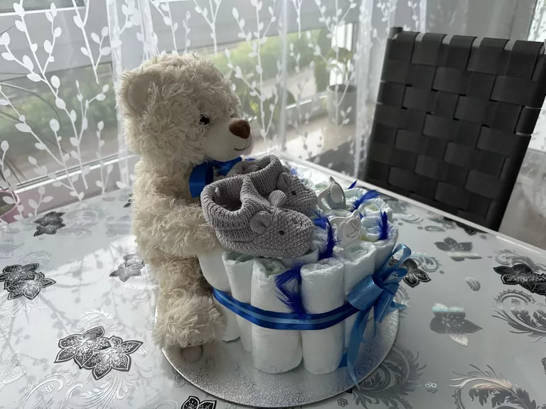 Plüschbär mit kleinen Schuhen, Schnullern und ein Windelpaket